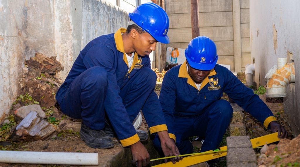 Bricklaying students checking brickwork with a spirit level at Pinnacle Technical Academy Johannesburg