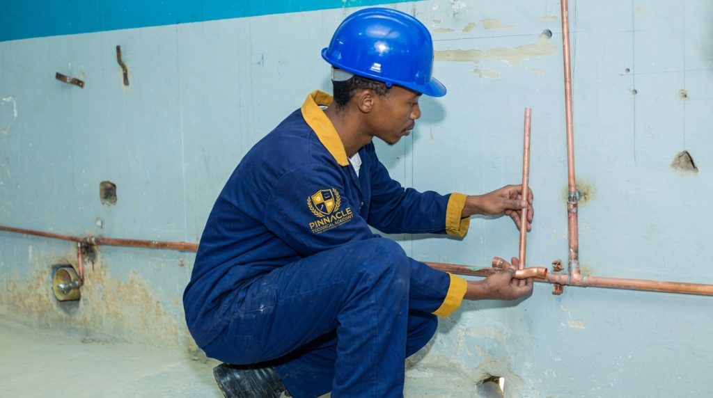 Pipe fitter student installing copper piping on a wall at Pinnacle Technical Academy Johannesburg